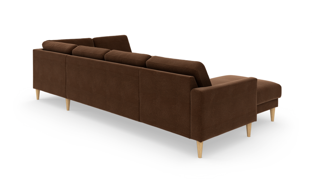 Brun modulsofa med chaiselong og lyse træben, set skråt bagfra i studie.