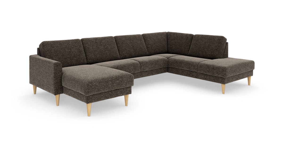 Mørkebrun U‑formet modulsofa i stof med chaiselong i begge ender og koniske lyse træben, frilagt på hvid baggrund.