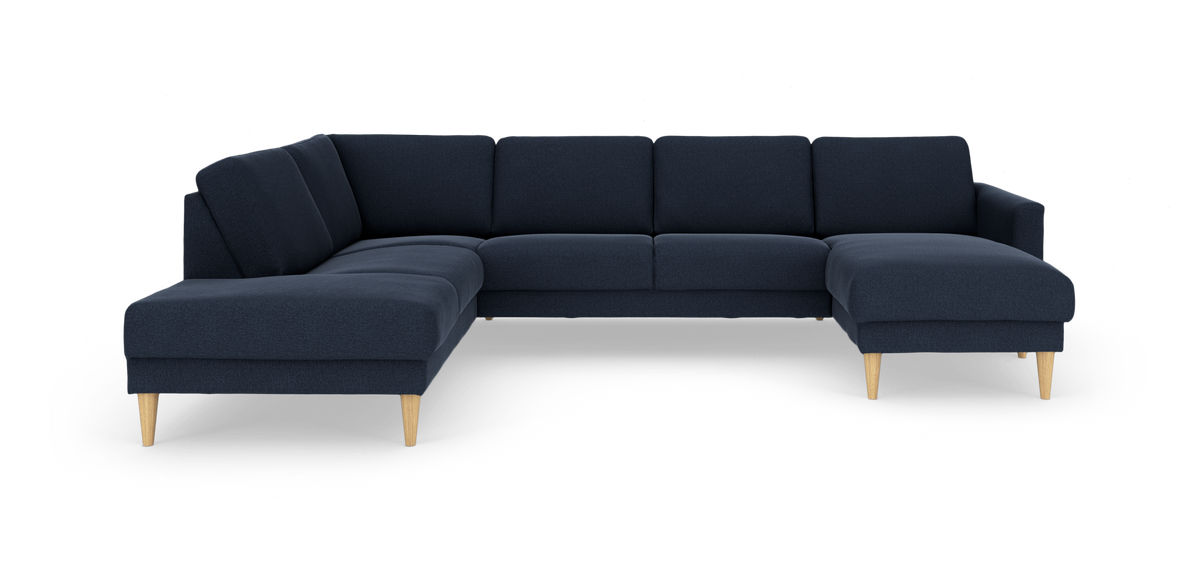 Mørkeblå L-formet hjørnesofa med chaiselong til højre og lyse træben, fritlagt på hvid baggrund.
