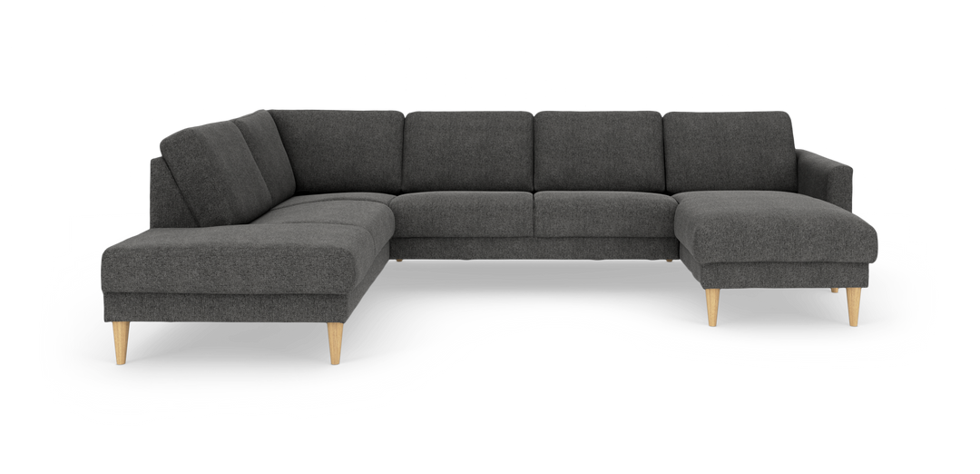 Mørkegrå hjørnesofa i stof med chaiselong og lyse træben, frilagt på hvid baggrund.