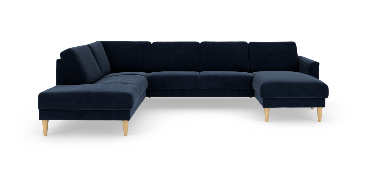 Stor mørkeblå hjørnesofa i stof med højre chaiselong og koniske ben i lyst træ, frilagt på hvid baggrund.