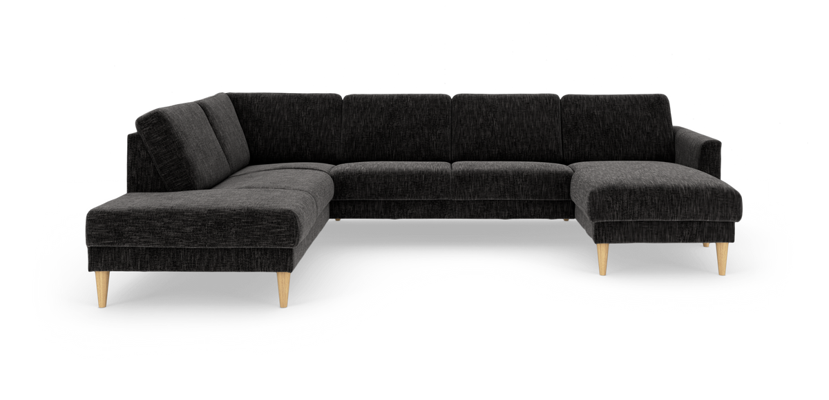 Mørkegrå L‑formet hjørnesofa med chaiselong til højre og koniske ben i lyst træ, frilagt på hvid baggrund.