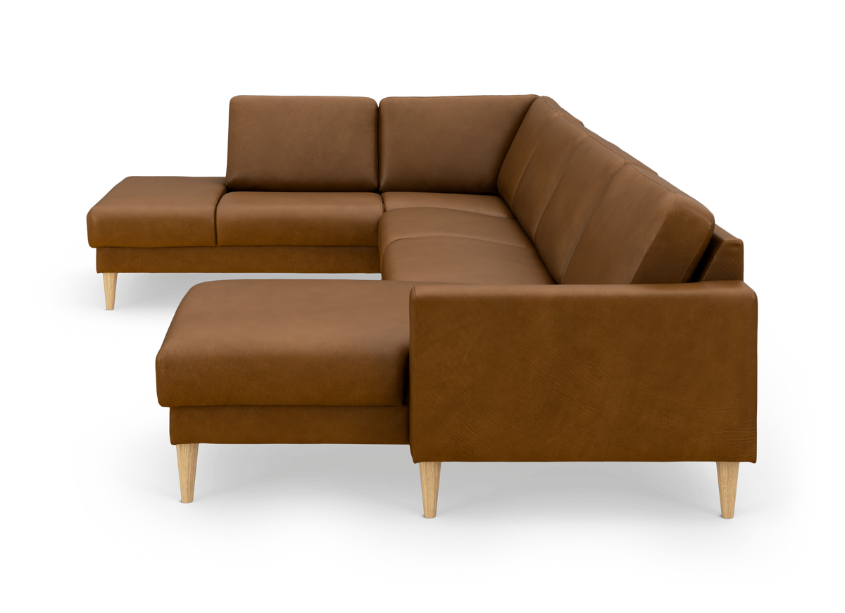 Brun L-formet hjørnesofa i læder med chaiselong og lyse træben, frilagt på hvid baggrund.