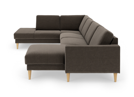 Modulær L‑sofa i mørkebrunt stof med chaiselong og lyse træben, fotograferet i studie fra front i vinkel.