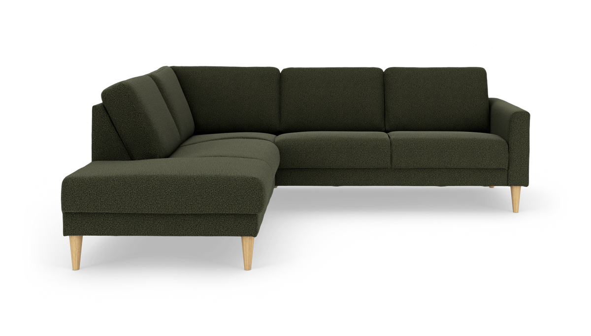 Mørkegrøn L-sofa med venstrevendt chaiselong og lyse træben, frilagt på hvid baggrund.