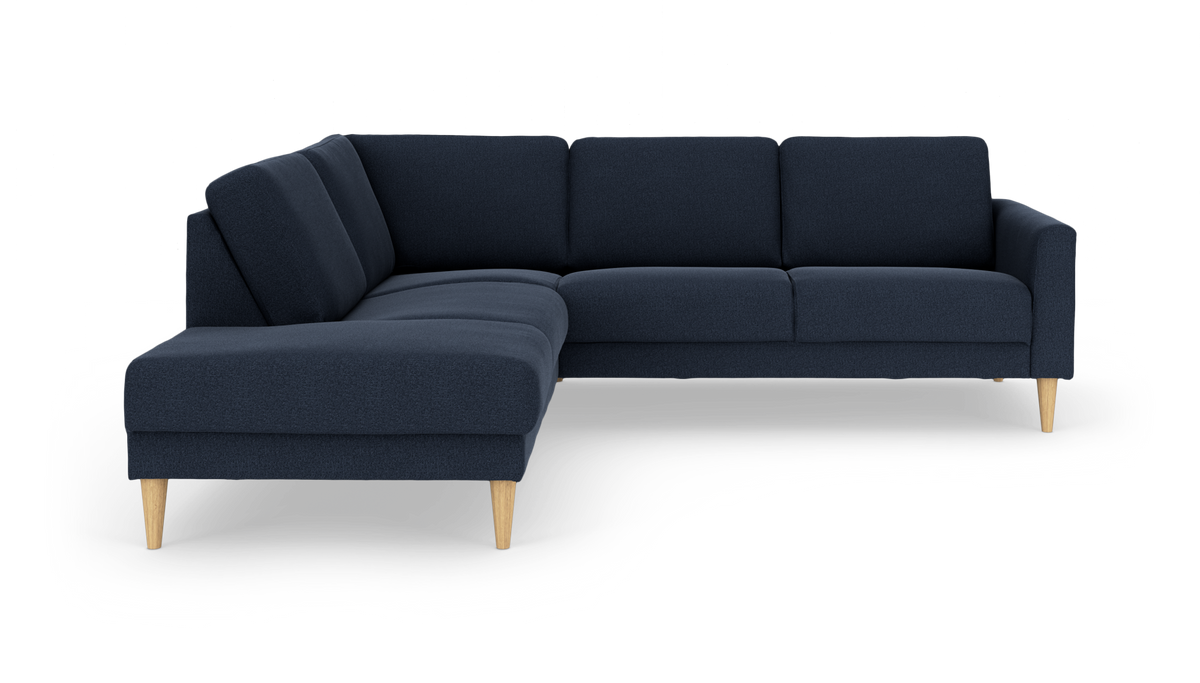 Mørkeblå hjørnesofa med chaiselong til venstre og lyse træben.
