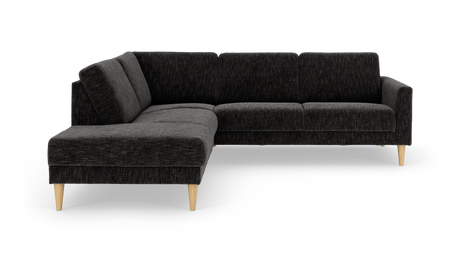 Mørkegrå L‑formet hjørnesofa med chaiselong og koniske ben i lyst træ, frilagt på hvid baggrund.