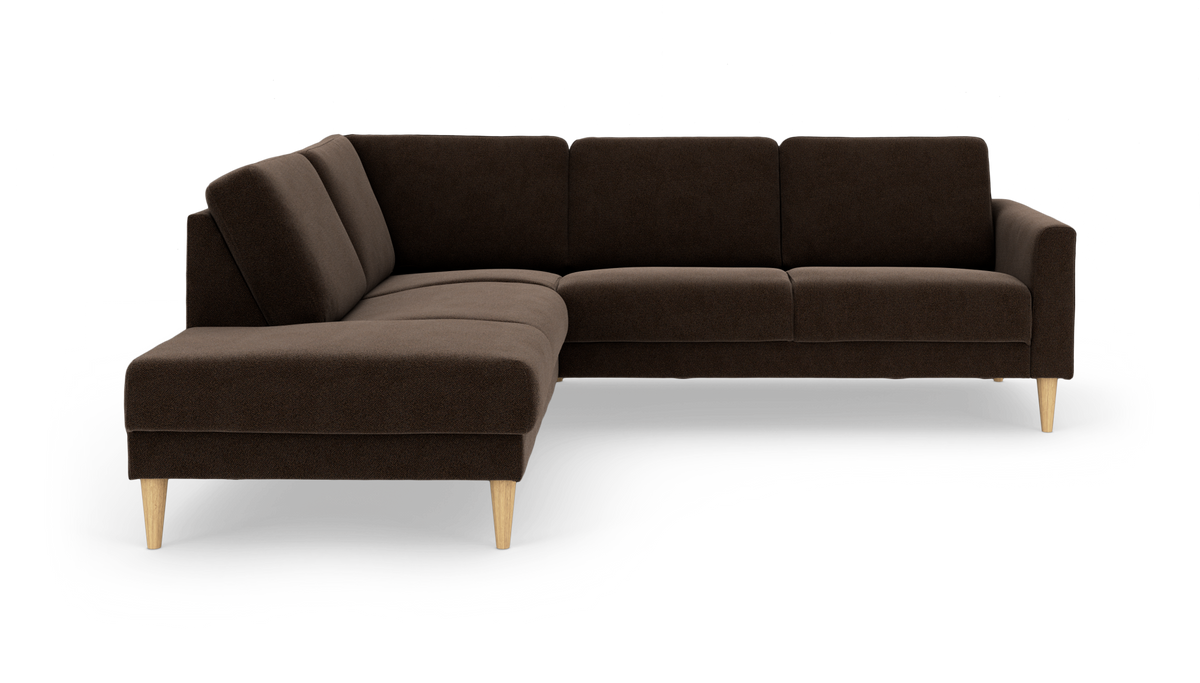 Mørkebrun L‑formet hjørnesofa med chaiselong til venstre og koniske træben, frilagt på hvid baggrund.