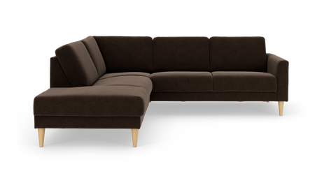 Mørkebrun L‑formet hjørnesofa med chaiselong til venstre og koniske træben, frilagt på hvid baggrund.