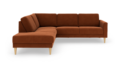 Rustfarvet L-formet hjørnesofa med chaiselong til venstre og koniske lyse træben, fritstående på hvid baggrund.