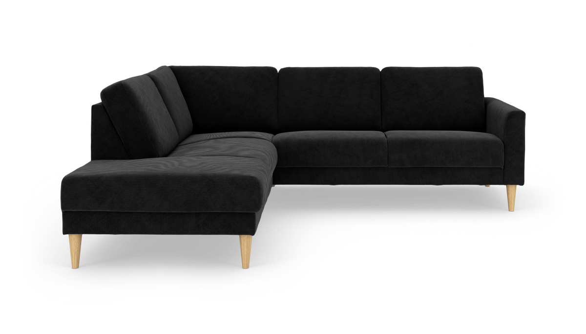 Sort hjørnesofa med chaiselong til venstre og koniske træben, fritlagt på hvid baggrund.