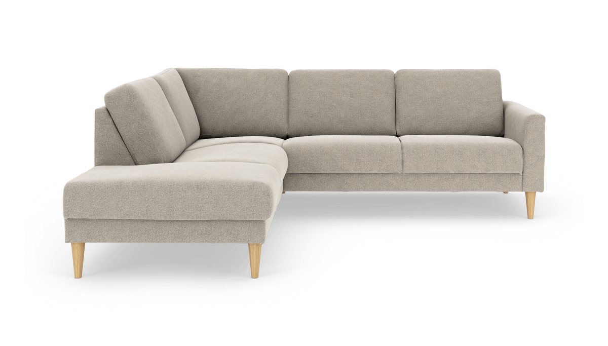 Beige L-formet hjørnesofa i stof med koniske ben i lyst træ, frilagt på hvid baggrund.