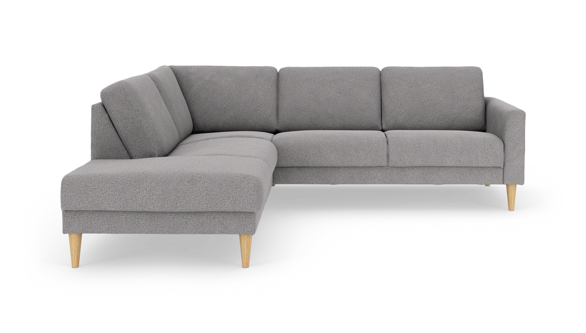 Grå L-formet hjørnesofa med venstrevendt chaiselong og lyse træben, frilagt på hvid baggrund.