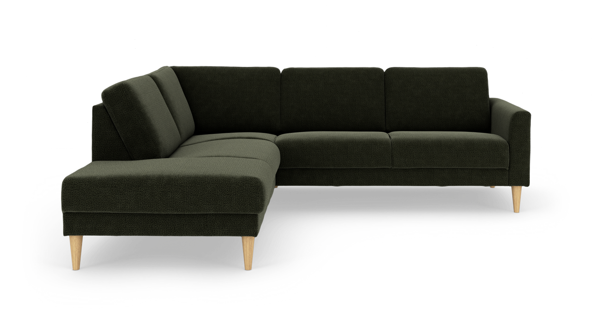 Mørkegrøn L‑sofa med venstrevendt chaiselong og lyse træben, fritlagt på hvid baggrund.