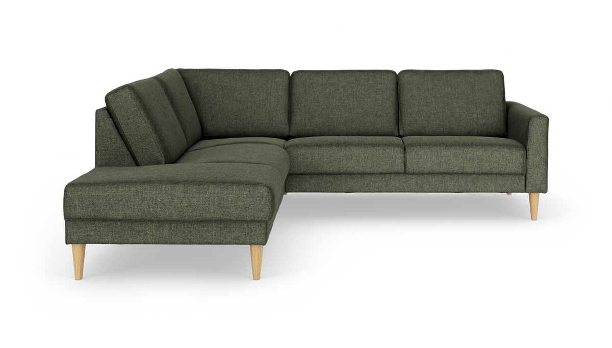 Grøn L‑formet hjørnesofa med chaiselong til venstre og lyse træben, fritlagt på hvid baggrund.
