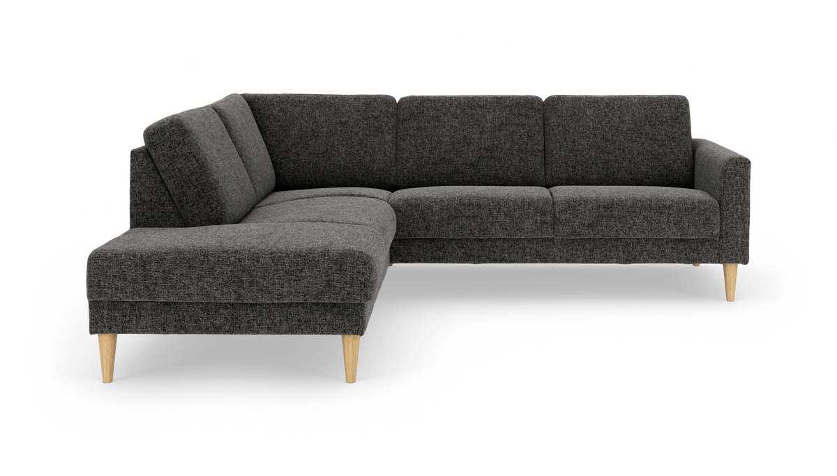 Mørkegrå L‑sofa i stof med træben, chaiselong til venstre.