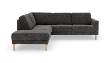 Mørkegrå L‑sofa i stof med træben, chaiselong til venstre.