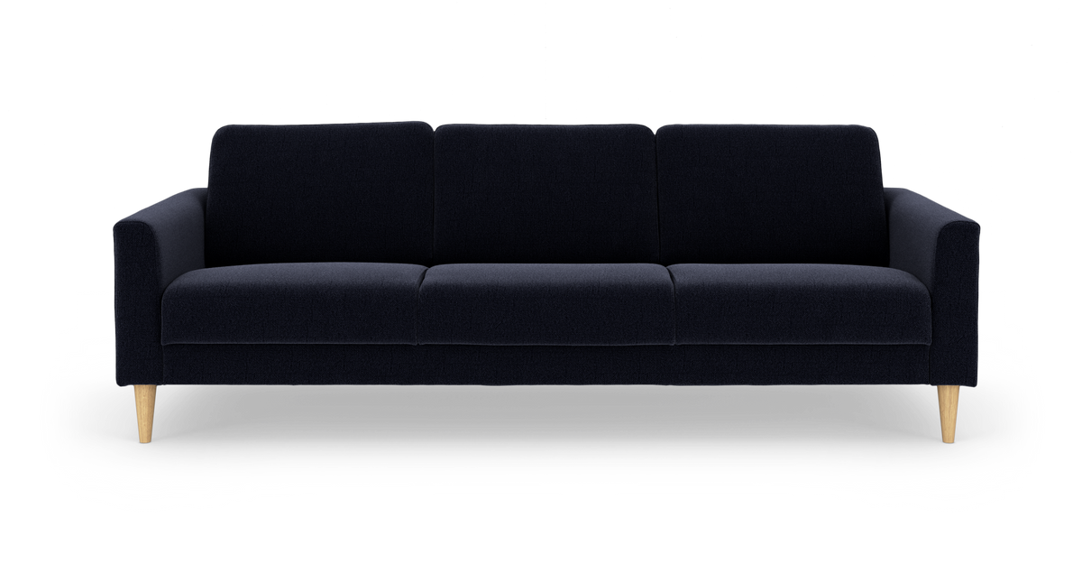 Mørkeblå tresæders sofa i stof med træben, fritlagt på hvid baggrund.