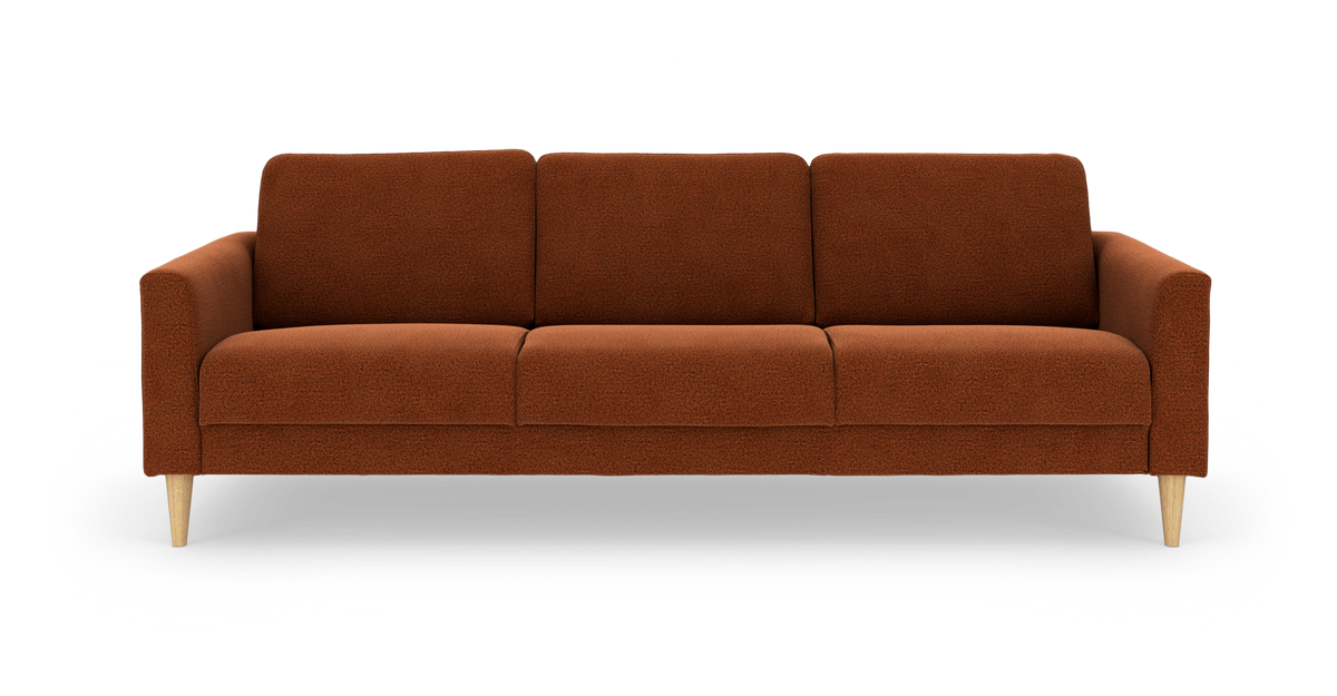 Tresæders sofa i rustorange stof med lyse, koniske træben, frilagt på hvid baggrund.