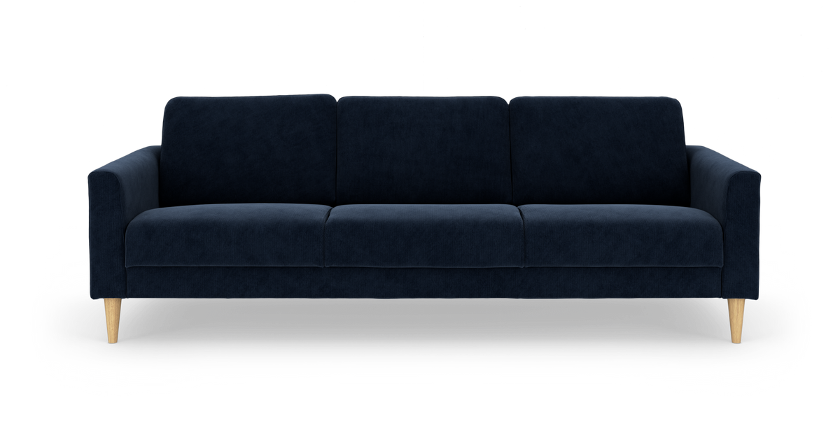 Mørkeblå sofa med fire sædehynder og lyse træben, set lige forfra mod hvid baggrund.