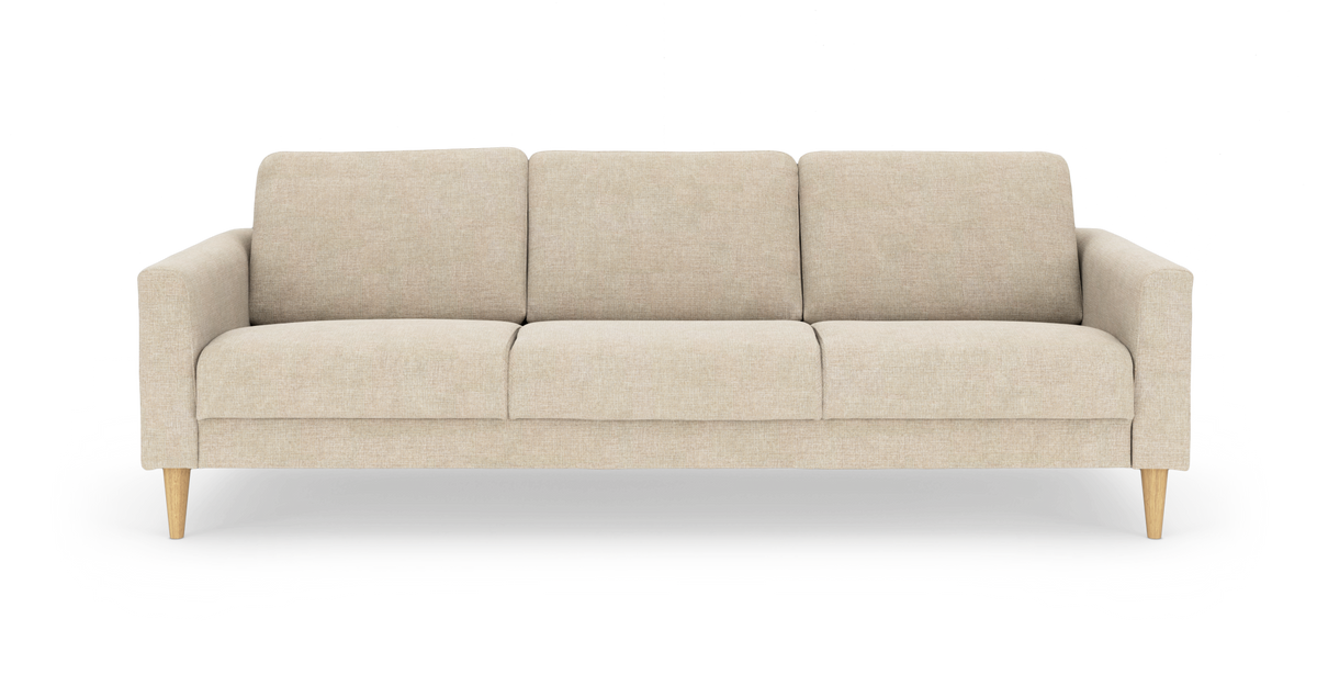 Beige 3-personers sofa med bløde puder og træben, fotograferet forfra mod hvid baggrund.