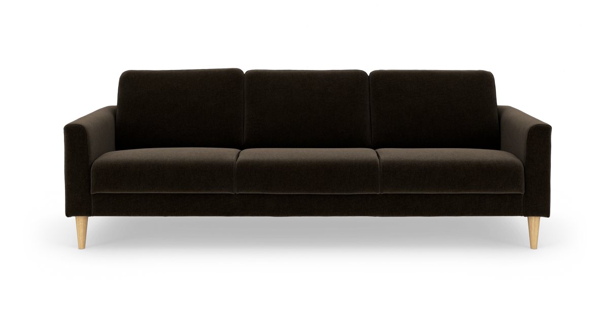 Mørkebrun 3-personers stofsofa med tre rygpuder og koniske ben i lyst træ, set forfra.
