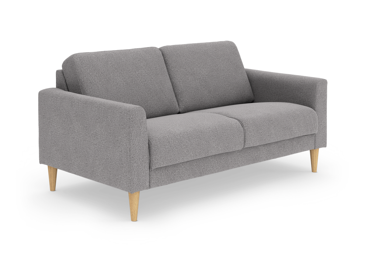 Grå stofsofa med to sædehynder og koniske ben i lyst træ, frilagt på hvid baggrund.