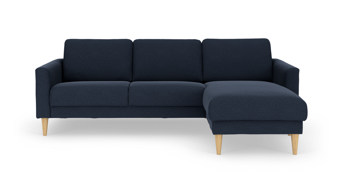 Mørkeblå hjørnesofa med højre chaiselong og lyse træben, frontvisning.
