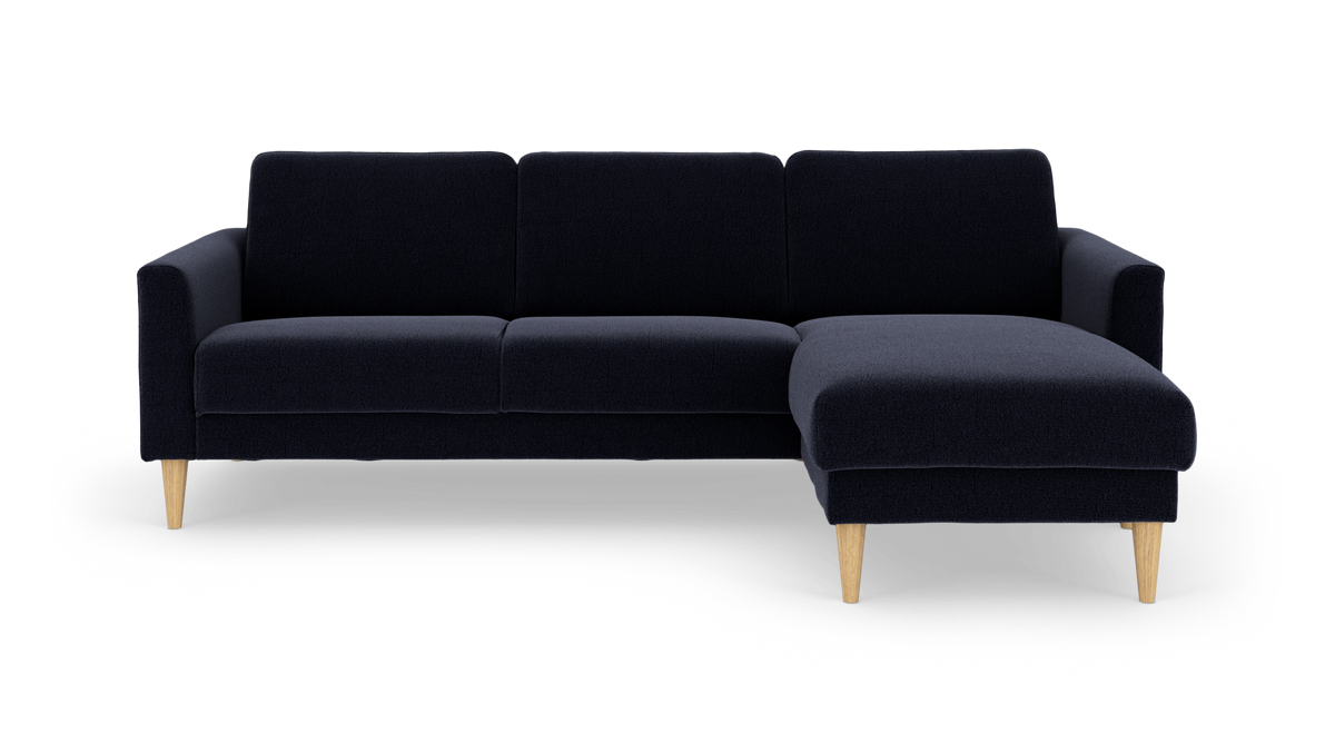 Mørkeblå hjørnesofa med højre chaiselong og lyse træben.
