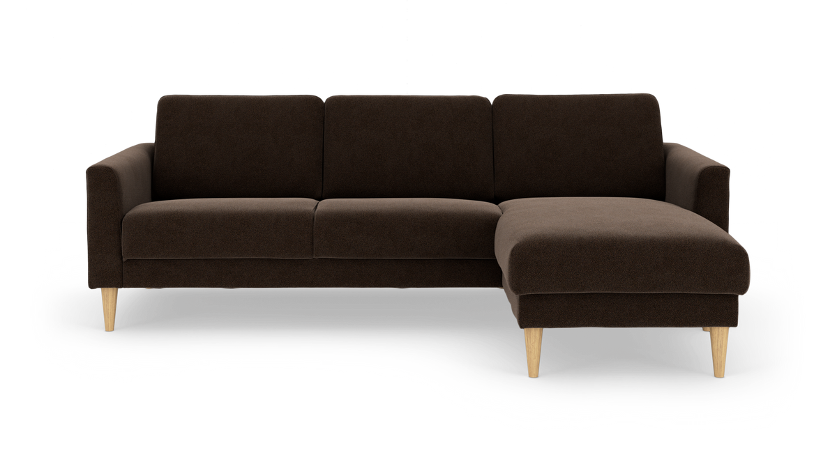 Brun hjørnesofa med chaiselong til højre og lyse træben, frilagt på hvid baggrund.