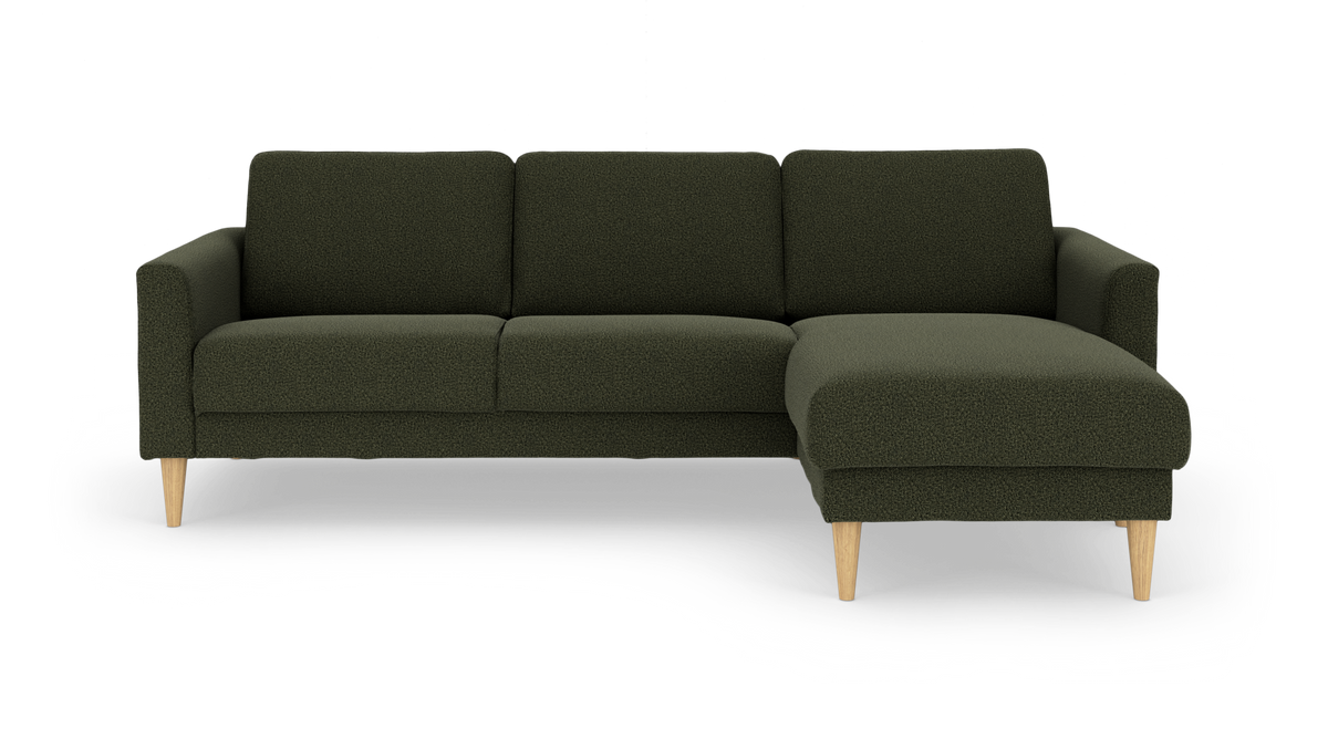 Mørkegrøn modulsofa med chaiselong til højre, lyse træben, frilagt på hvid baggrund.