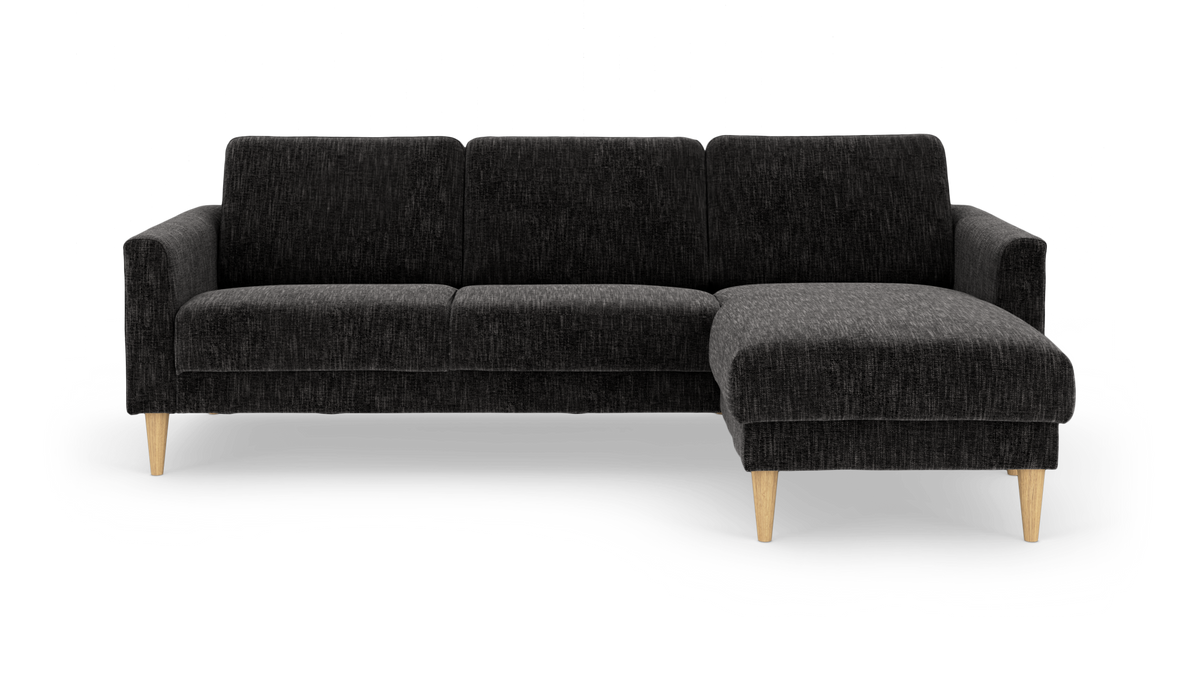 Mørkegrå hjørnesofa med højre chaiselong og koniske ben i lyst træ.