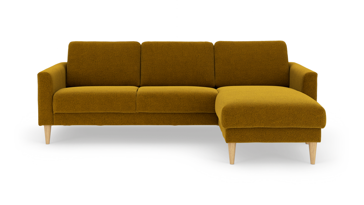 Sennepsgul hjørnesofa med højre chaiselong og koniske træben, fritlagt på hvid baggrund.