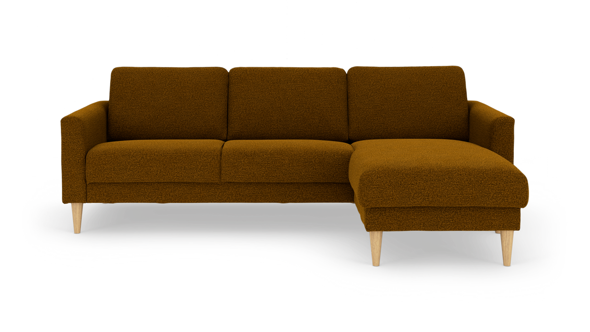 Sennepsgul/brun 3-personers sofa med chaiselong til højre, bouclé-lignende stof og lyse koniske træben, frilagt på hvid baggrund.