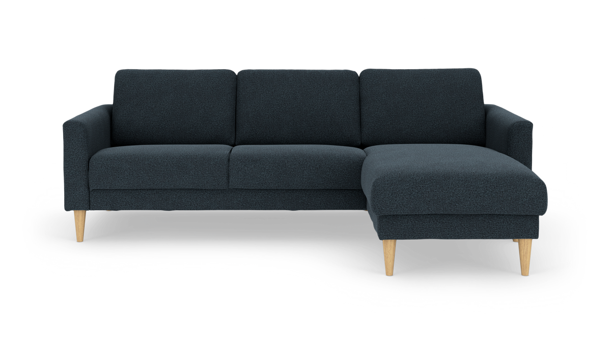 Mørkeblå hjørnesofa med højre chaiselong og lyse træben.
