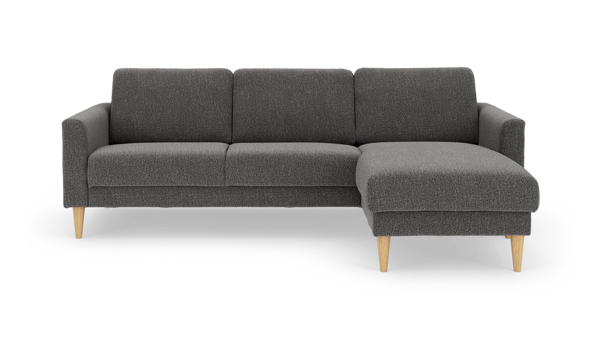 Mørkegrå hjørnesofa med højrevendt chaiselong og lyse træben, frilagt på hvid baggrund.