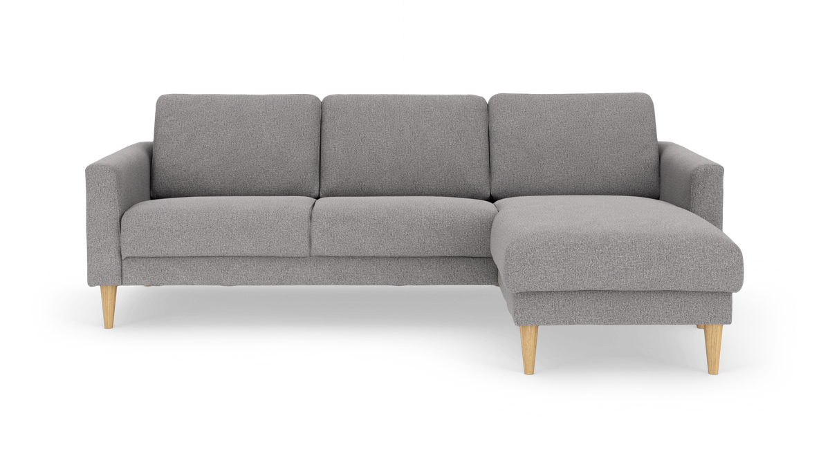 Grå modulsofa med chaiselong til højre og lyse træben, frilagt på hvid baggrund.