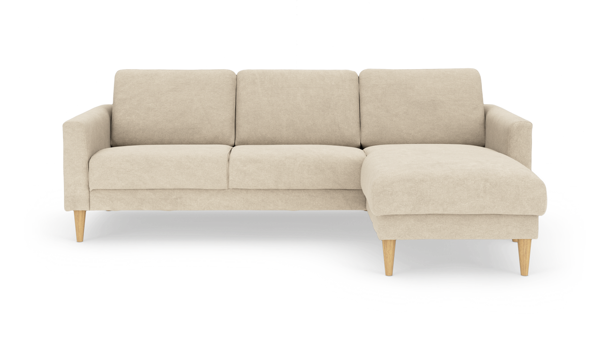 Beige hjørnesofa med chaiselong til højre på træben, frilagt på hvid baggrund.