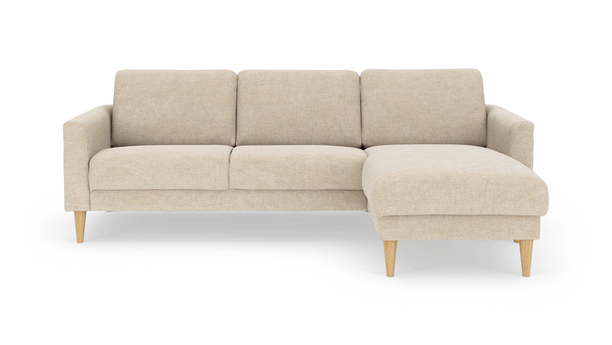 Beige hjørnesofa med chaiselong til højre og koniske træben, frilagt på hvid baggrund.