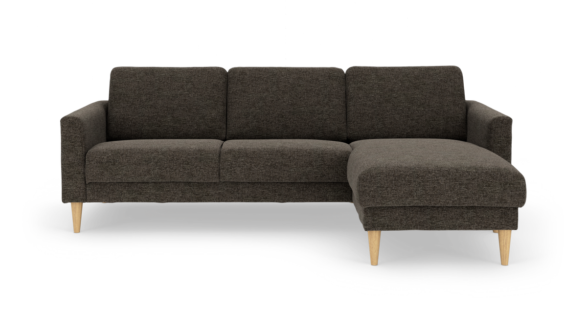 Mørkegrå hjørnesofa med chaiselong til højre og lyse træben.