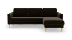 Mørkebrun hjørnesofa med chaiselong til højre og koniske træben.