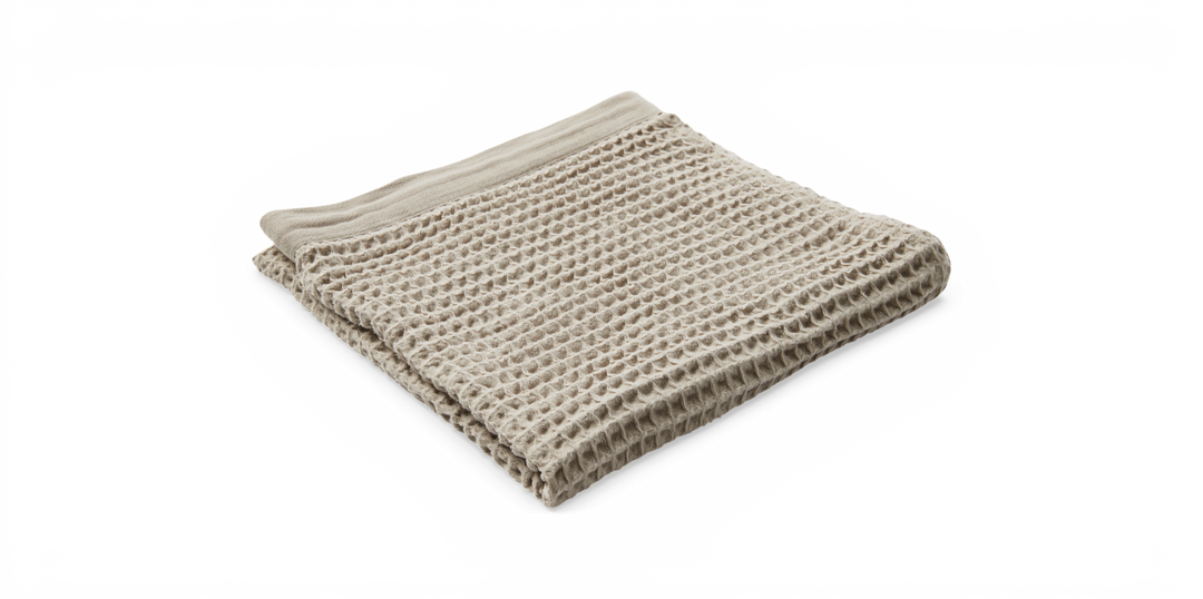 Beige plaid i vaffelvæv, sammenfoldet og fotograferet i studie.