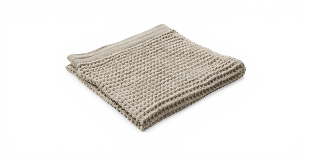 Beige plaid i vaffelvæv, sammenfoldet og fotograferet i studie.