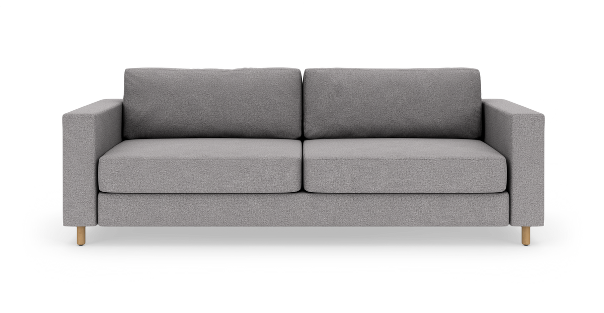 Grå sofa i moderne, minimalistisk design med firkantede armlæn og lyse træben på hvid baggrund.