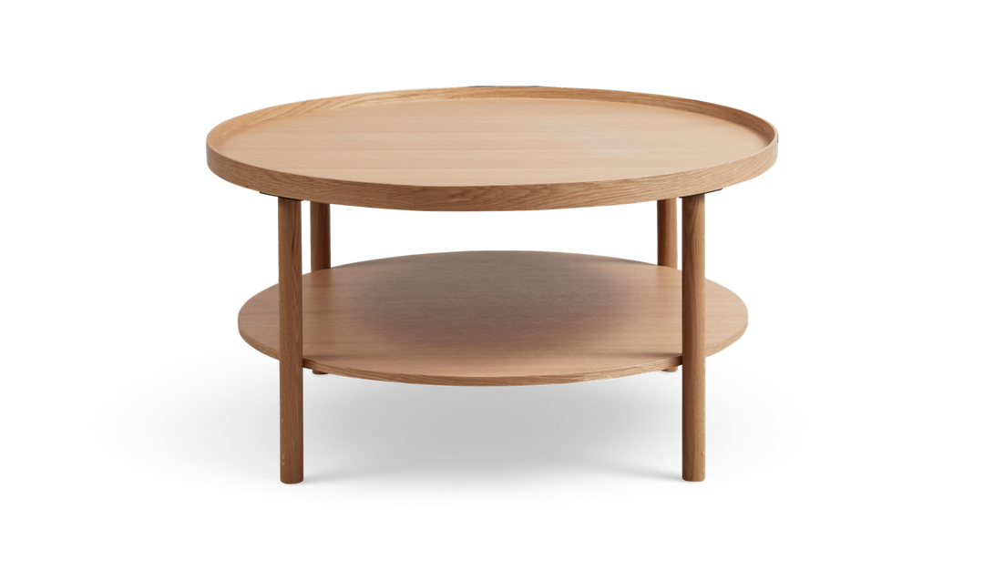Rundt sofabord i lys eg med to hylder og forhøjet kant, minimalistisk design.