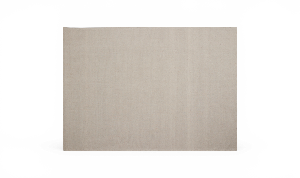 Beige rektangulært tæppe på neutral baggrund.