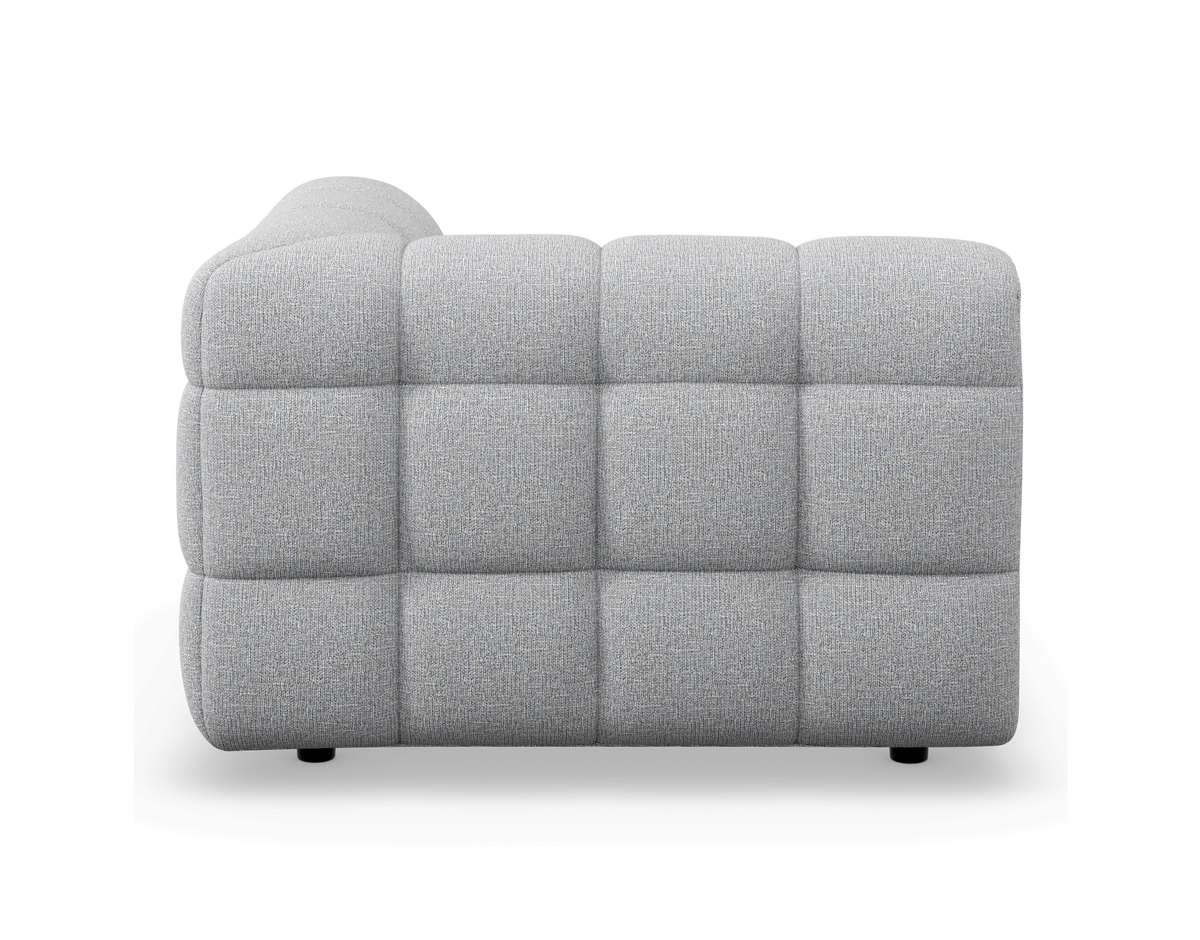 Grå modulsofa set fra siden, med vatteret ternemønster mod hvid studiobaggrund.