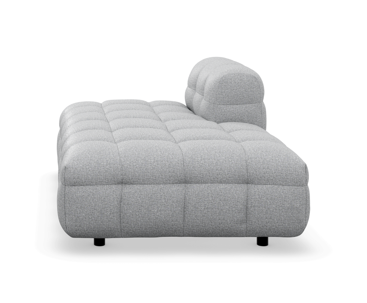 Grå tuftet modulsofa/chaise med lav profil, frilagt på hvid baggrund.