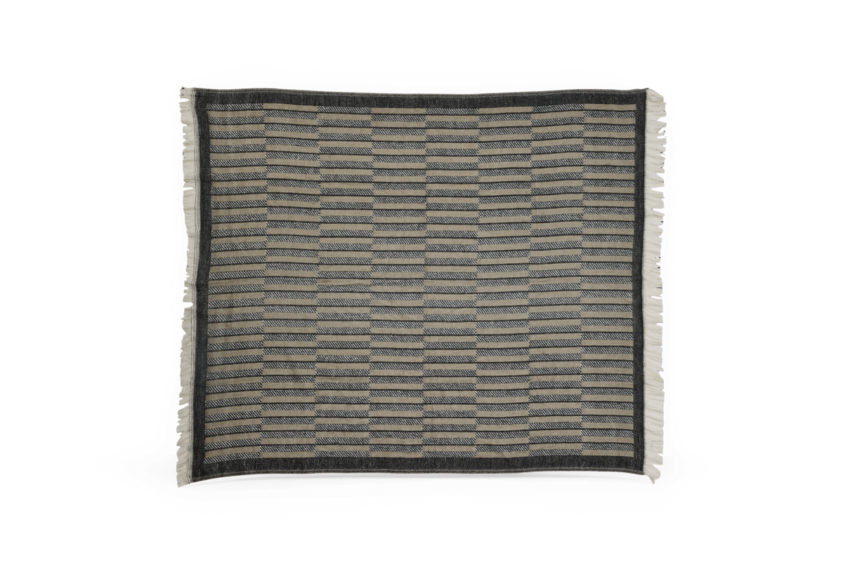 Mønstret, rektangulær plaid i grå og beige med mørk kant og frynser langs siderne.
