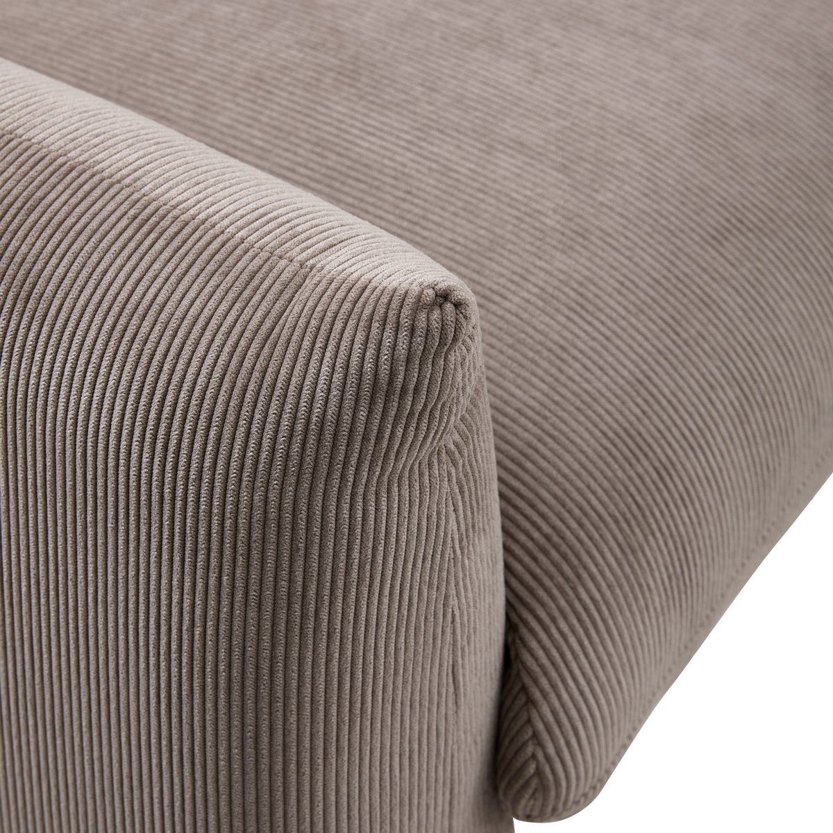 Nærbillede af et sofa-hjørne i beige bredriflet fløjl, der viser den bløde ribbede tekstur.